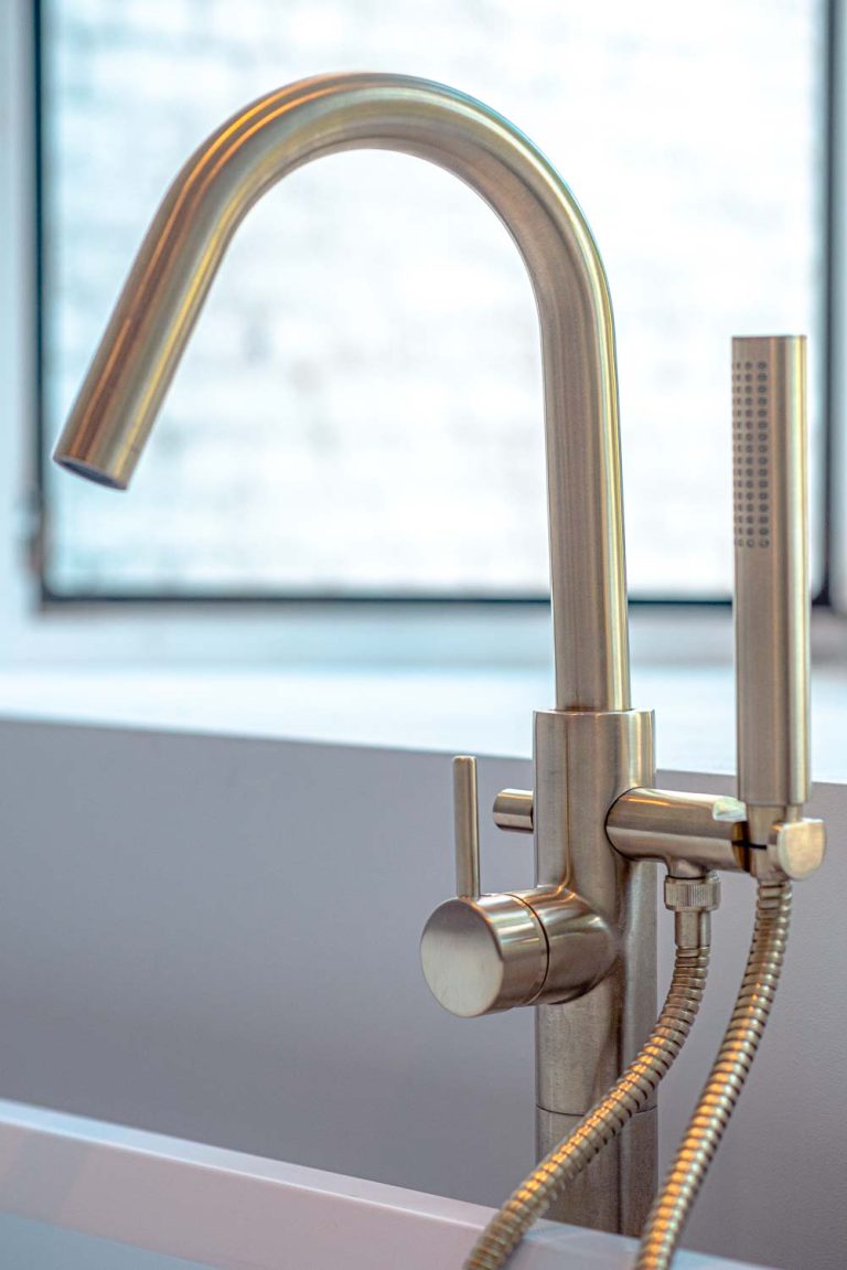 koperkleurige badkraan in een recente badkamerrenovatie